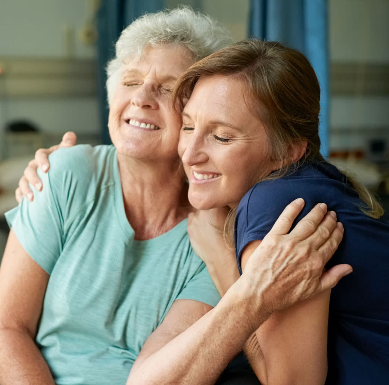 happy younger woman hugging happy older woman