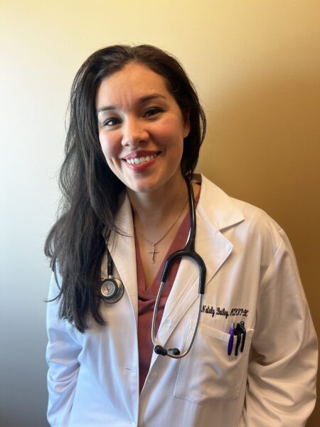 May contain a person wearing a white doctor's coat, stethoscope, and name tag.