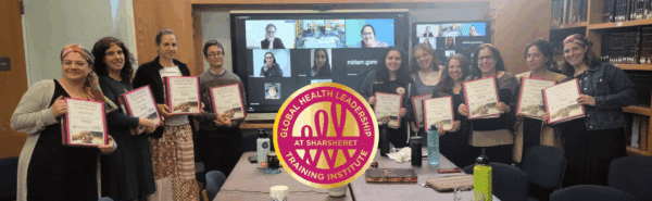 A group of women holding certificates stand in a classroom, with others visible on a large video screen behind them. A circular Sharsheret Global Health Leadership Training Institute logo is centered in the foreground.